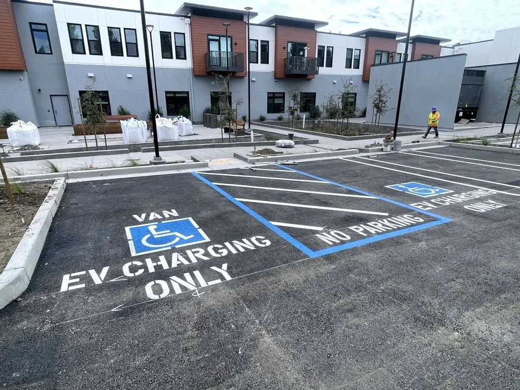 A new van-accessible stall with a no-parking access aisle, striped and stencilled for EV charging only.