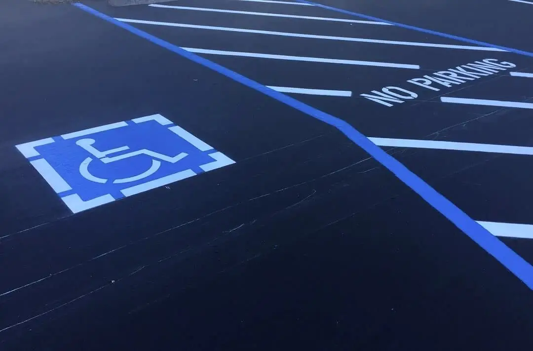Accessible parking signage and stall markings installed at a commercial parking lot.