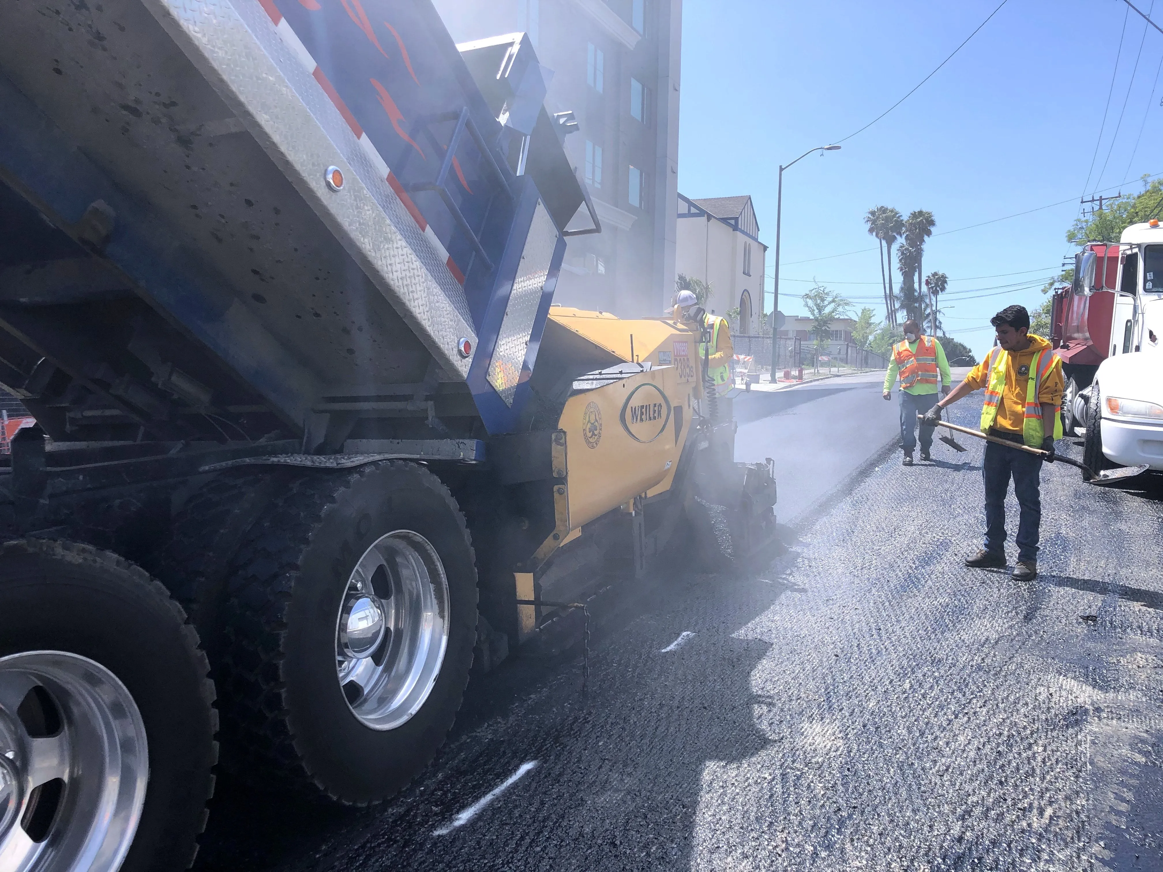 Hot-mix asphalt being fed to the paver during a commercial parking lot resurfacing.