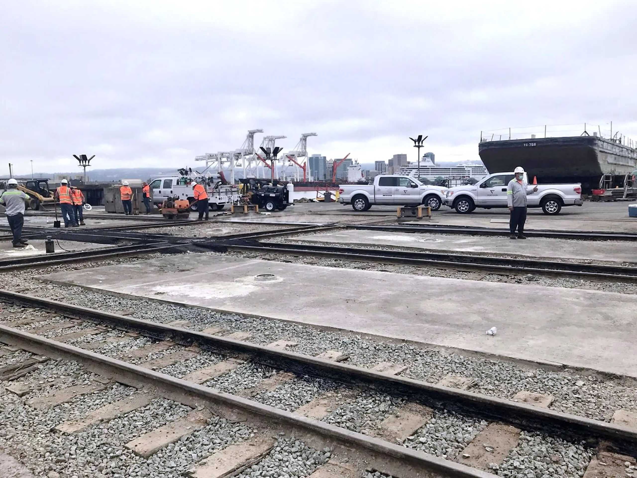 Rail tracks and new pavement across the Bay Ship Co. yard, with a vessel in dry dock beyond.