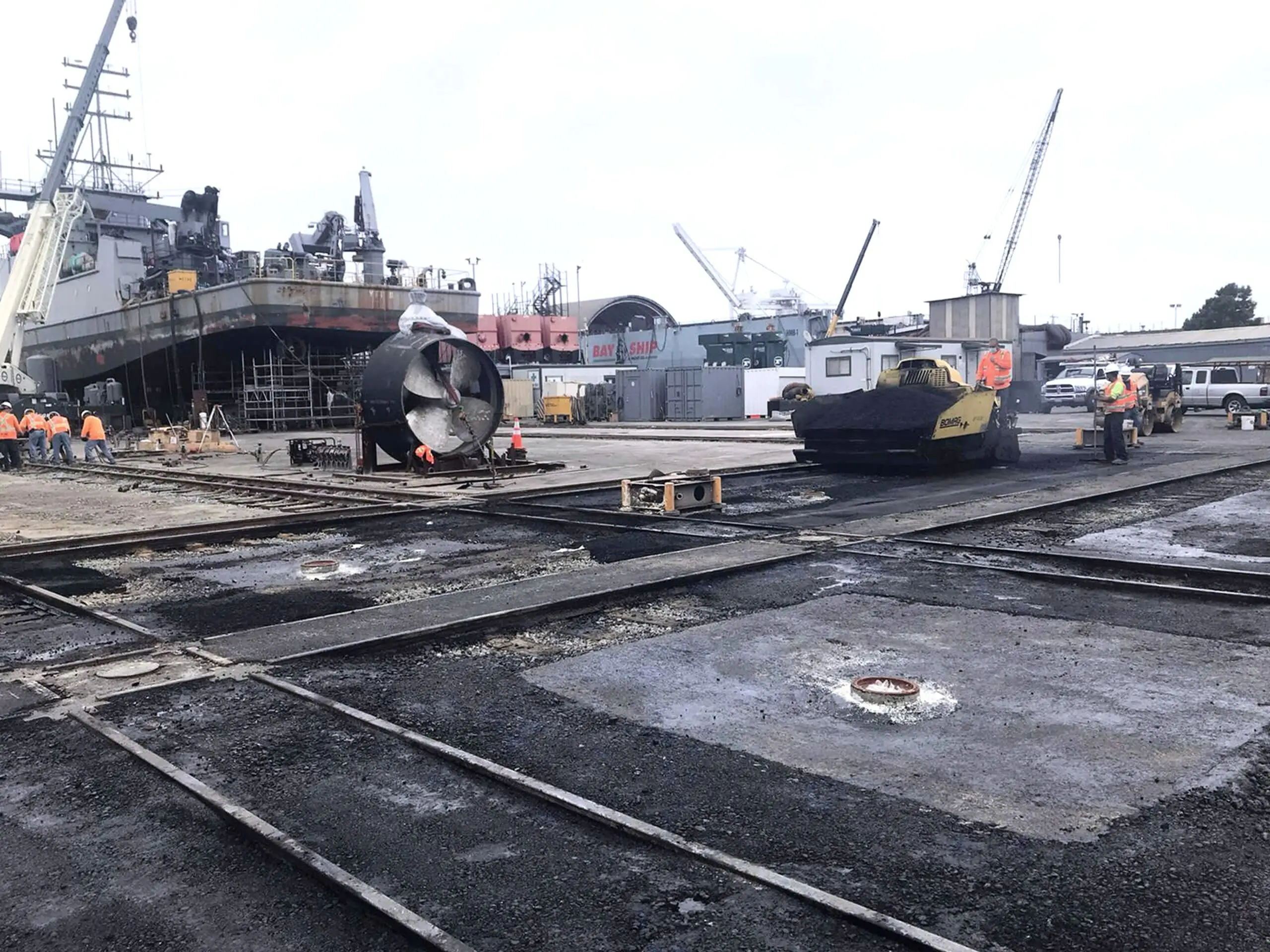 Completed pavement running through the Bay Ship Co. yard beneath the shipyard cranes.