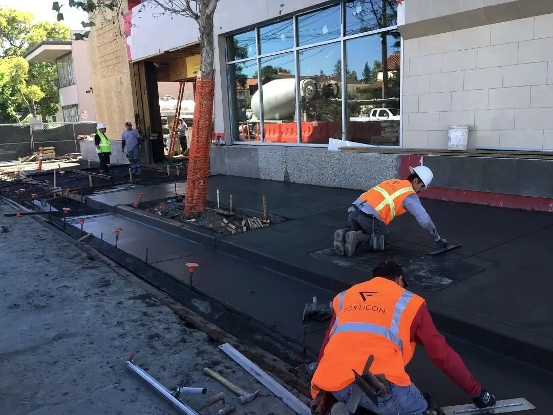 A Forticon crew placing and finishing a commercial concrete sidewalk section.