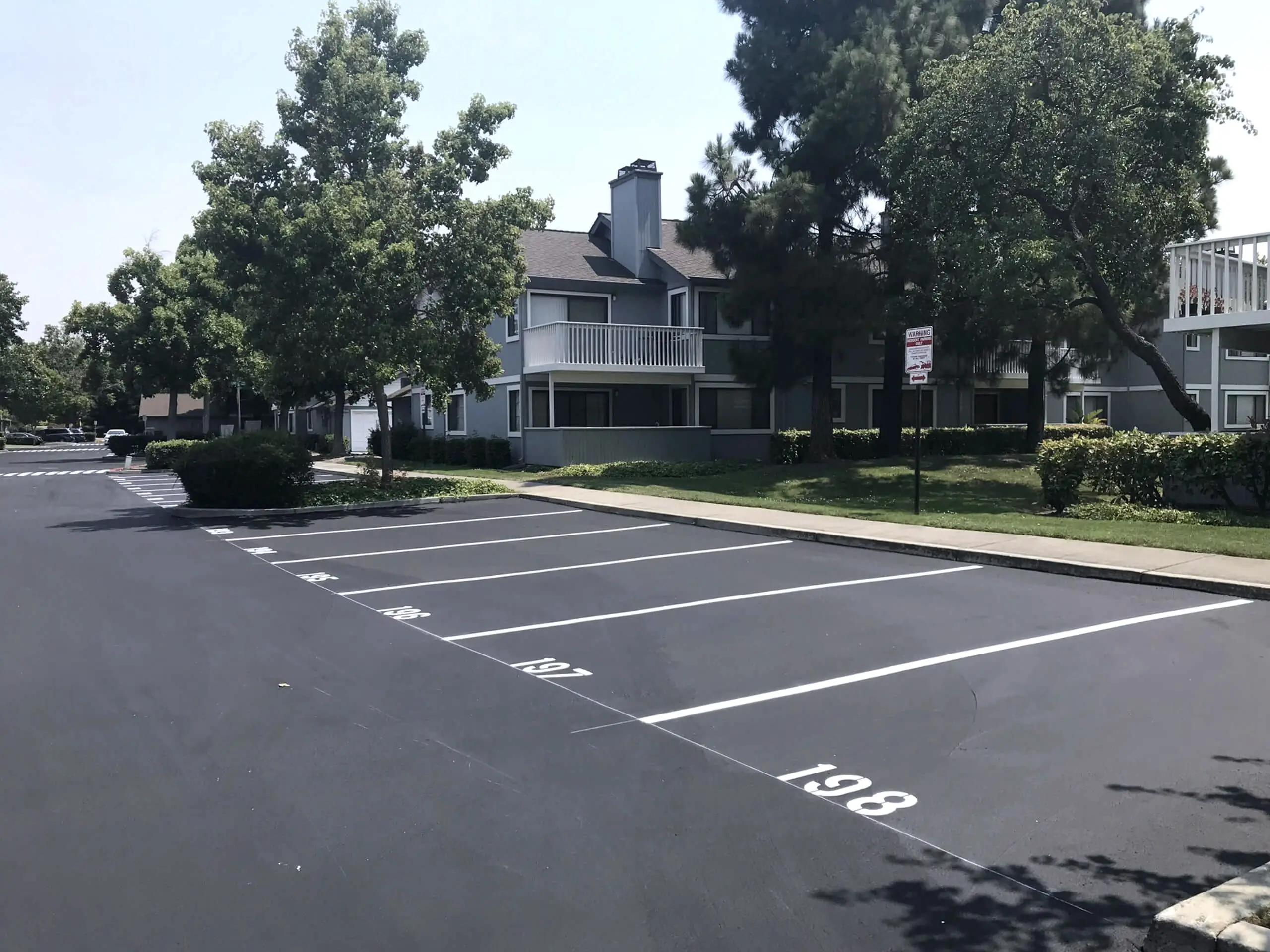 Parking stalls at The Crossings HOA with fresh white striping and stall identification numbering.