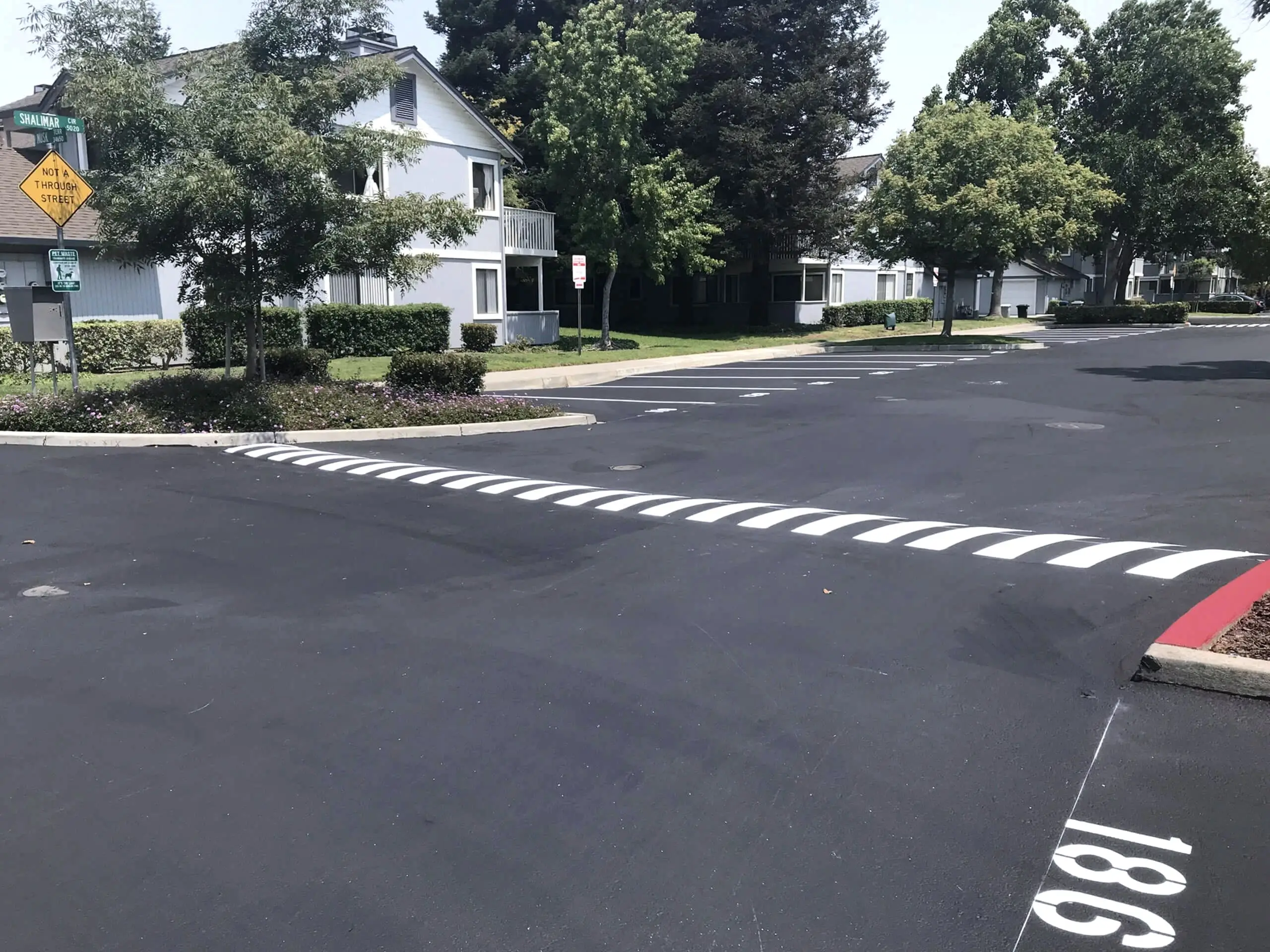 White hatched crosswalk markings across a community roadway at The Crossings HOA.