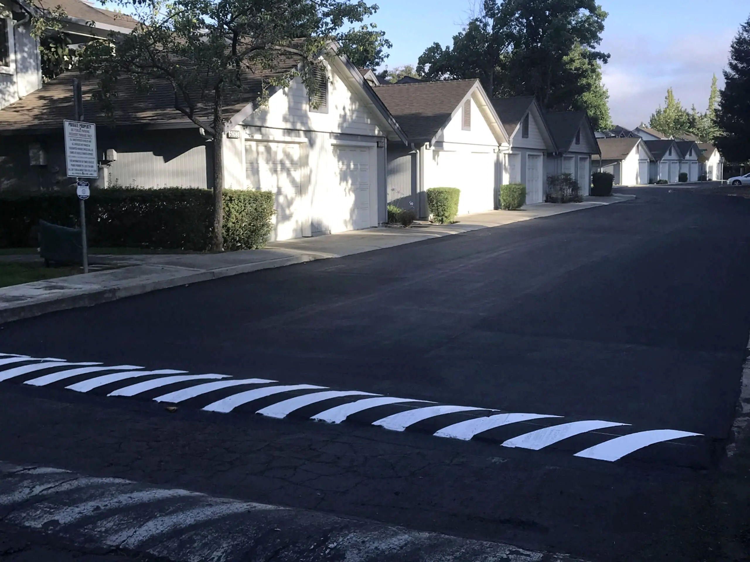 Blue and white chevron markings applied to a speed table on the new asphalt surface.