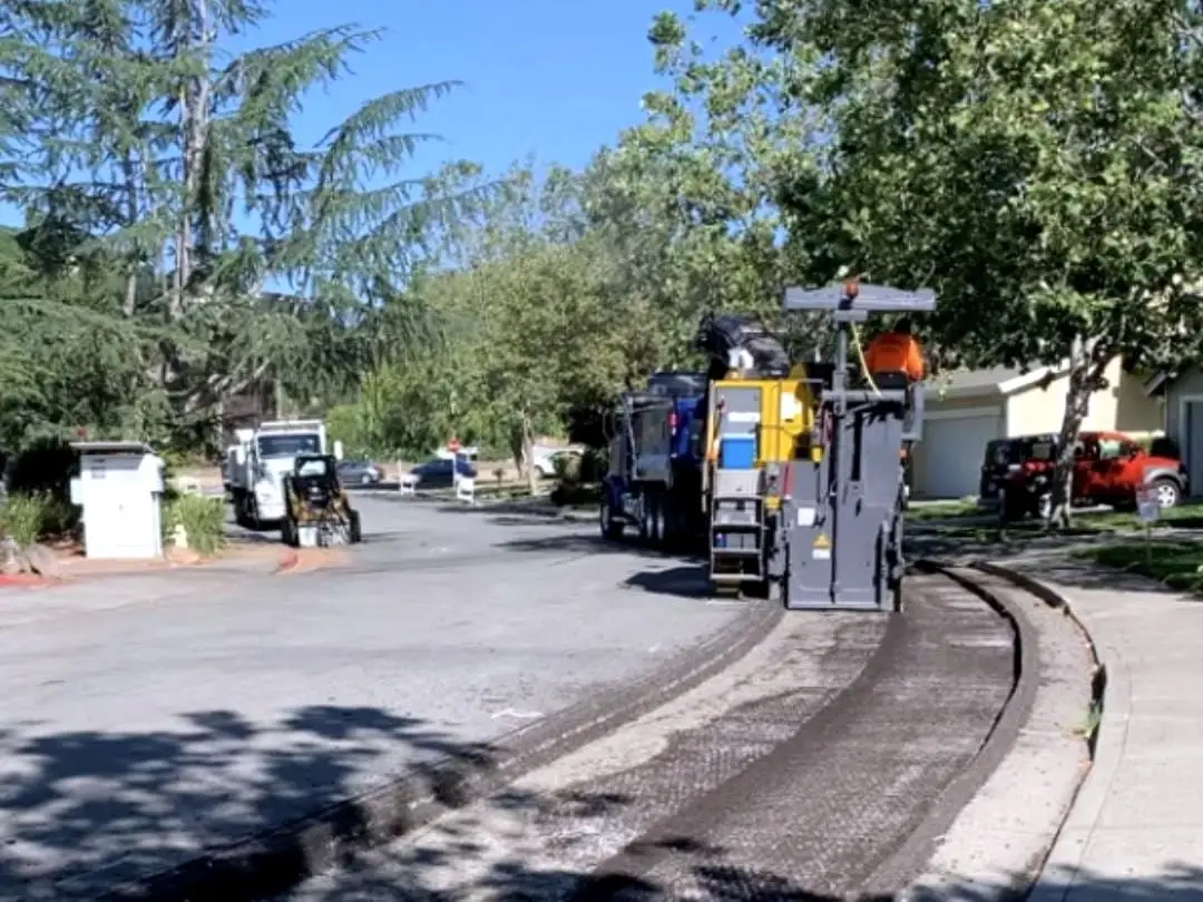 The paver and crew placing asphalt along a residential street at Marin Lagoon.