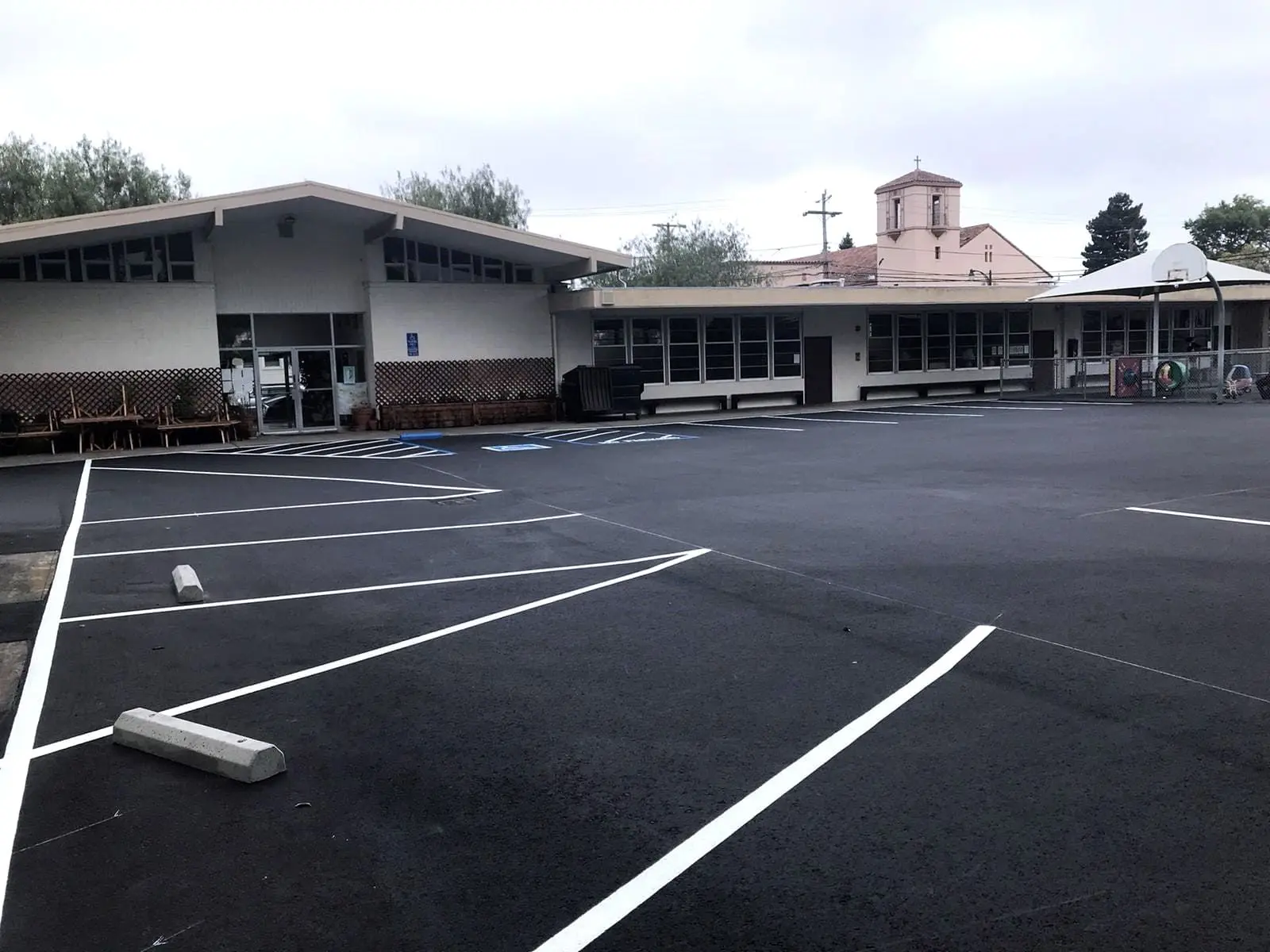 Crisp white stall striping across a newly surfaced commercial parking field in the Bay Area.