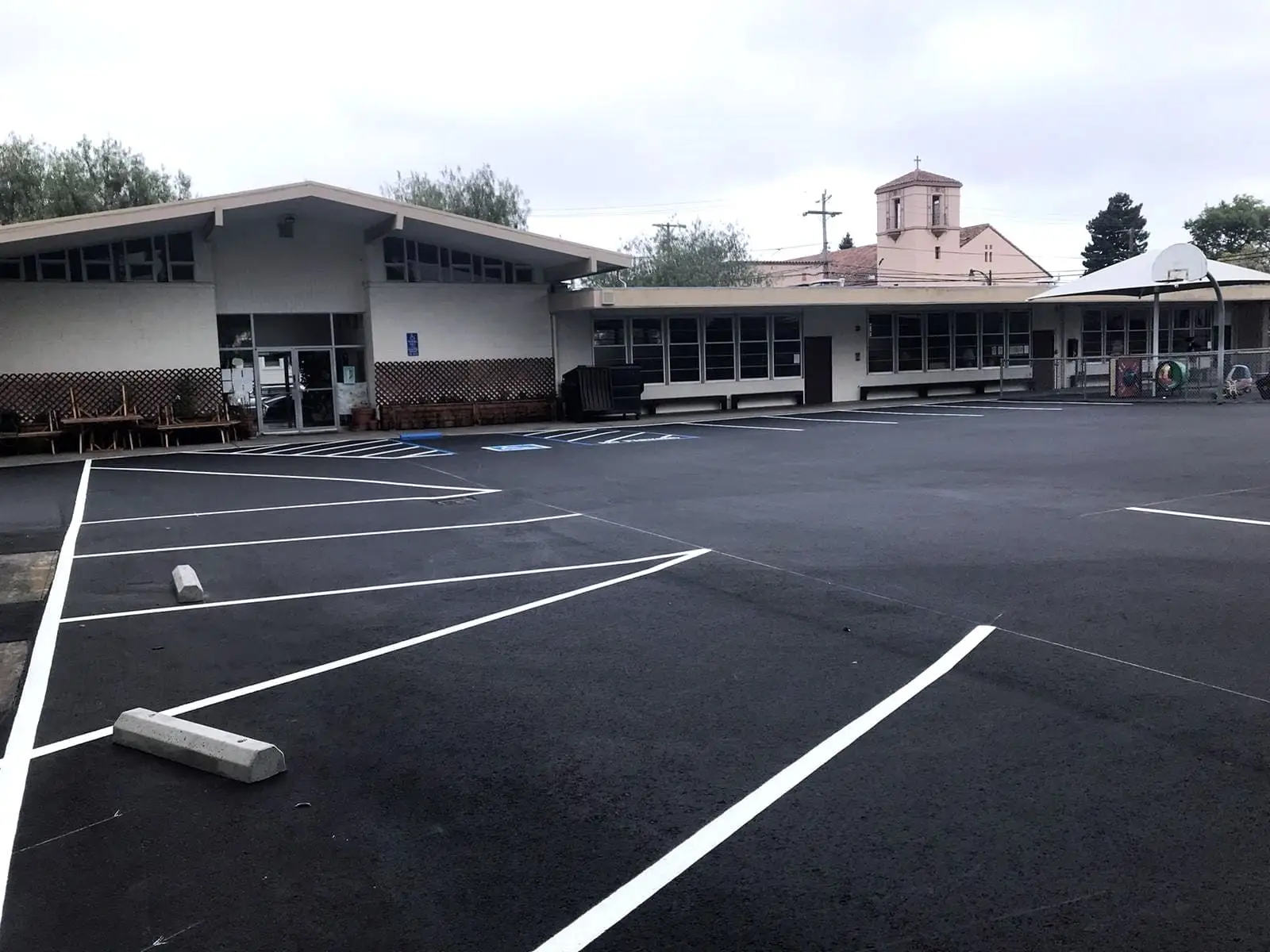 Crisp white stall striping across a newly surfaced commercial parking field in the Bay Area.